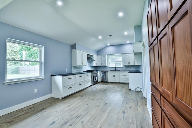 336 N Sherry Ave, Norman, OK 73069 - kitchen featuring appliances with stainless steel finishes, decorative backsplash, vaulted ceiling, dark countertops, and light wood finished floors