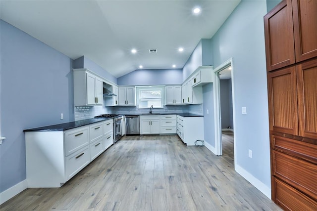 336 N Sherry Ave, Norman, OK 73069 - kitchen featuring dishwasher, dark countertops, lofted ceiling, tasteful backsplash, and light wood-style flooring
