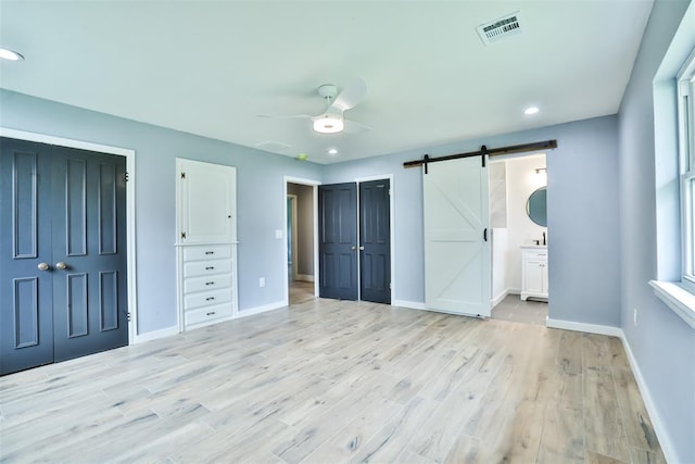 336 N Sherry Ave, Norman, OK 73069 - unfurnished bedroom with a barn door, light wood-style flooring, a closet, recessed lighting, and ceiling fan