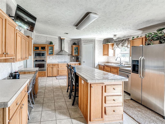19108 Finn Ridge Rd, Purcell, OK 73080 - kitchen featuring appliances with stainless steel finishes, wall chimney exhaust hood, ornamental molding, a sink, and light countertops