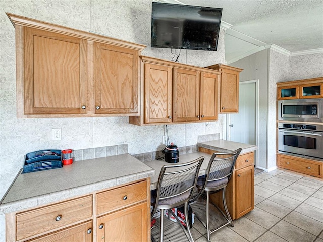19108 Finn Ridge Rd, Purcell, OK 73080 - kitchen featuring appliances with stainless steel finishes, ornamental molding, wallpapered walls, a textured ceiling, and light tile patterned flooring