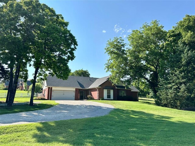 12 Northwood Dr, Shawnee, OK 74804 - ranch-style house with a garage, gravel driveway, a front lawn, and brick siding