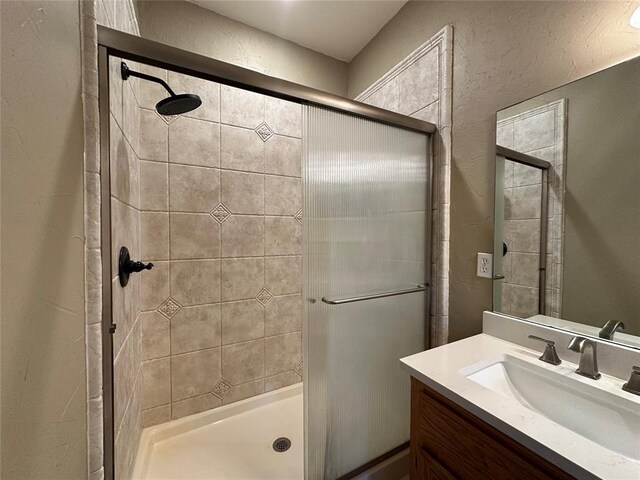 12 Northwood Dr, Shawnee, OK 74804 - bathroom featuring a stall shower, vanity, and a textured wall