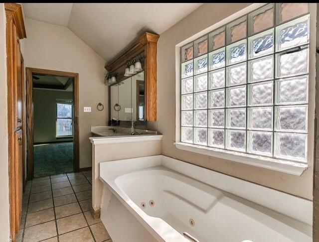 5704 Bent Creek Dr, Oklahoma City, OK 73135 - full bathroom with a tub with jets, vaulted ceiling, tile patterned flooring, and vanity