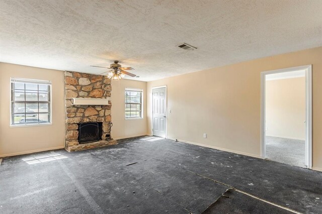 2604 N Ann Arbor Ave Unit 224, Oklahoma City, OK 73127 - unfurnished living room featuring a textured ceiling, ceiling fan, a stone fireplace, and carpet flooring
