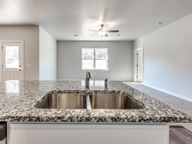 813 Stella Trl, Guthrie, OK 73044 - kitchen featuring a sink, ceiling fan, stone counters, open floor plan, and carpet