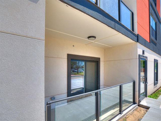 103 E Edwards St, Edmond, OK 73034 - view of exterior entry featuring stucco siding and a balcony
