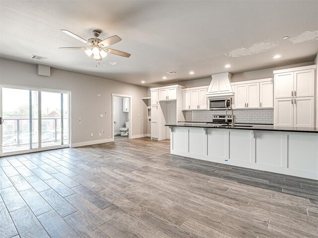 103 E Edwards St, Edmond, OK 73034 - kitchen with appliances with stainless steel finishes, baseboards, dark countertops, decorative backsplash, and ceiling fan