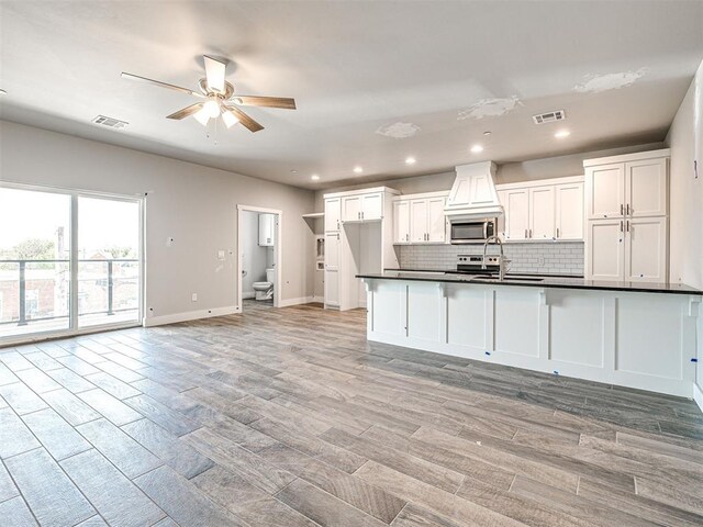 103 E Edwards St, Edmond, OK 73034 - kitchen with stainless steel microwave, a ceiling fan, dark countertops, backsplash, and recessed lighting