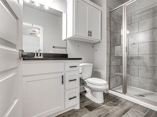 103 E Edwards St, Edmond, OK 73034 - bathroom with vanity, toilet, a shower stall, and ceiling fan