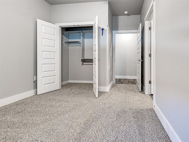 103 E Edwards St, Edmond, OK 73034 - unfurnished bedroom featuring a closet, light colored carpet, and baseboards