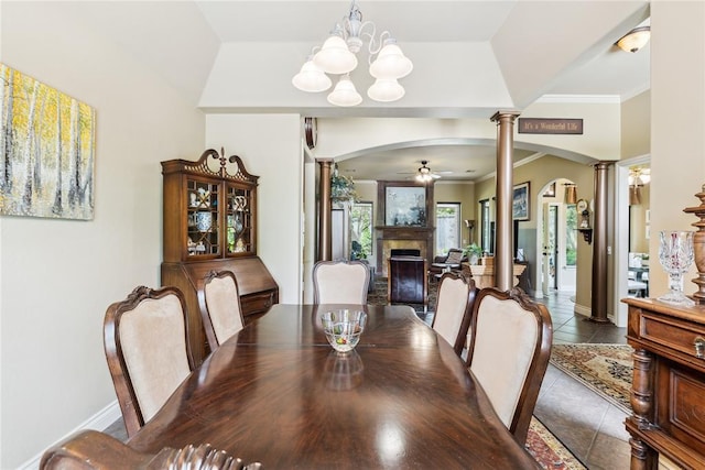 3201 Pinehurst Dr, Norman, OK 73072 - tiled dining area with ornate columns, arched walkways, a fireplace, a ceiling fan, and crown molding