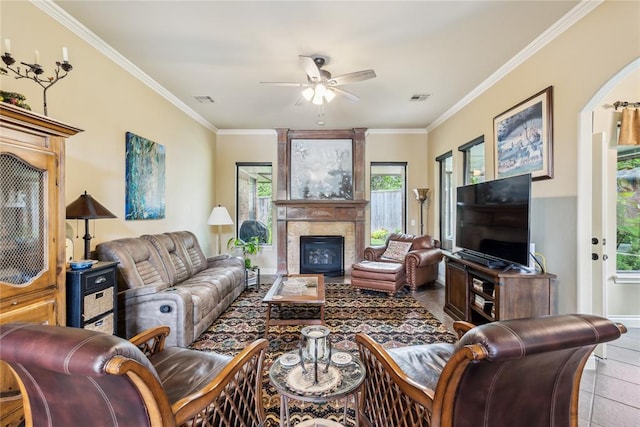 3201 Pinehurst Dr, Norman, OK 73072 - tiled living room featuring ceiling fan, a fireplace, crown molding, and arched walkways