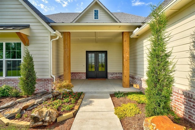 612 E Coffee Creek Rd, Edmond, OK 73034 - view of exterior entry with french doors, brick siding, and roof with shingles