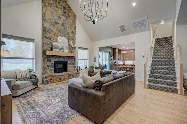 612 E Coffee Creek Rd, Edmond, OK 73034 - living room with high vaulted ceiling, light wood-type flooring, stairs, a chandelier, and a fireplace