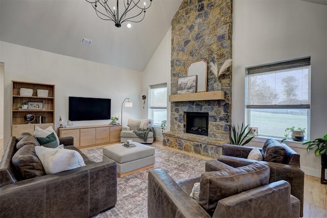 612 E Coffee Creek Rd, Edmond, OK 73034 - living room featuring high vaulted ceiling, wood finished floors, a chandelier, healthy amount of natural light, and a stone fireplace