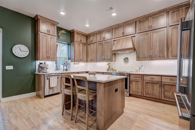 612 E Coffee Creek Rd, Edmond, OK 73034 - kitchen with premium range hood, stainless steel appliances, light wood-type flooring, light countertops, and recessed lighting