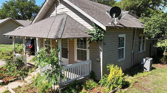 305 N Reimer St, Corn, OK 73024 - view of front of home featuring covered porch, roof with shingles, and central AC