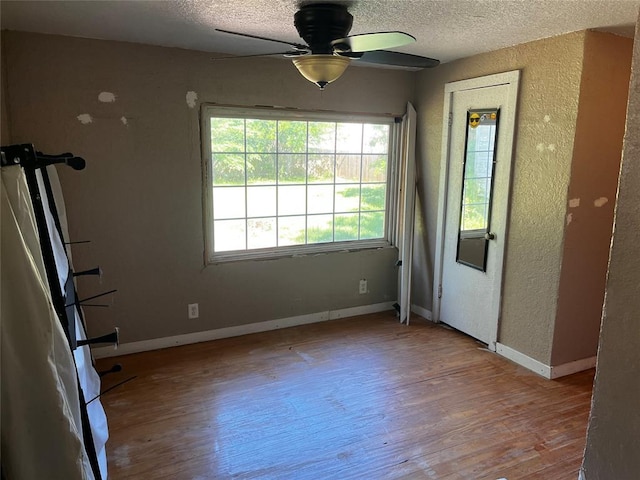 305 N Reimer St, Corn, OK 73024 - unfurnished room with ceiling fan, wood finished floors, a textured ceiling, a textured wall, and baseboards