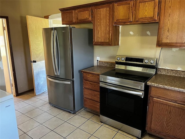 305 N Reimer St, Corn, OK 73024 - kitchen with appliances with stainless steel finishes, dark countertops, brown cabinets, and light tile patterned floors
