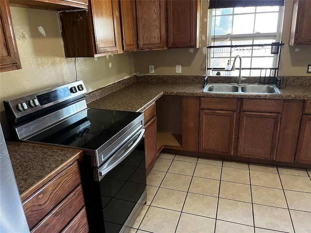 305 N Reimer St, Corn, OK 73024 - kitchen with stainless steel range with electric cooktop, a sink, dark countertops, and light tile patterned floors