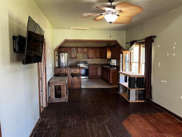 305 N Reimer St, Corn, OK 73024 - kitchen featuring appliances with stainless steel finishes, dark countertops, a sink, light wood-style floors, and ceiling fan