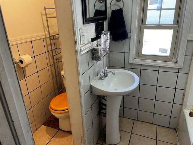 305 N Reimer St, Corn, OK 73024 - bathroom with tile walls, toilet, tile patterned flooring, a tub to relax in, and a sink