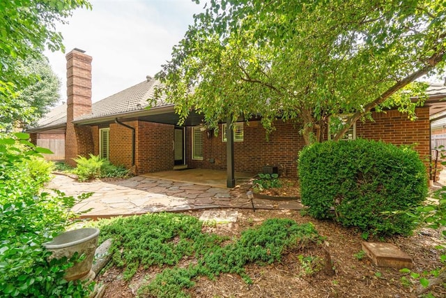 4113 Old Farm Rd, Oklahoma City, OK 73120 - back of house featuring brick siding, a patio area, and a chimney