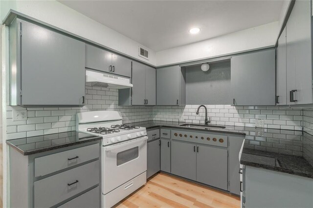 508 S Morrison Ave, El Reno, OK 73036 - kitchen with white gas range, under cabinet range hood, a sink, gray cabinetry, and recessed lighting