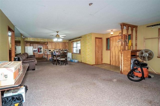 living area featuring a ceiling fan, carpet floors, and baseboards
