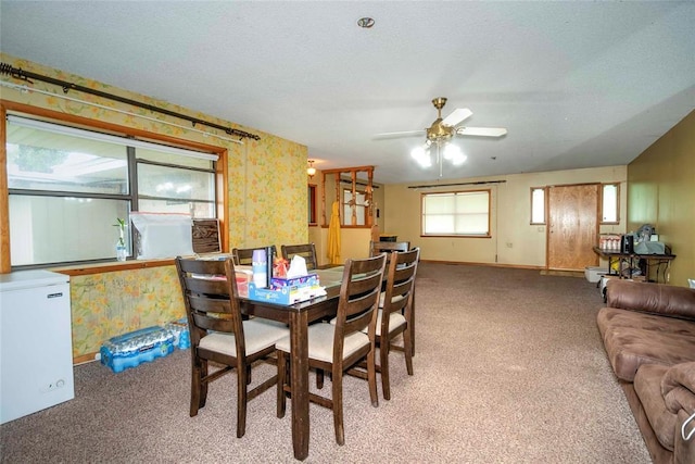 dining room with carpet flooring, wallpapered walls, a ceiling fan, and baseboards