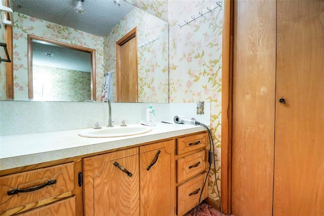 bathroom with wallpapered walls and vanity