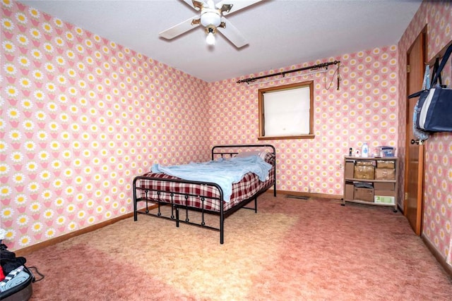 carpeted bedroom with wallpapered walls, ceiling fan, and baseboards
