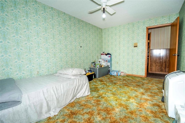 bedroom with wallpapered walls, carpet floors, and ceiling fan
