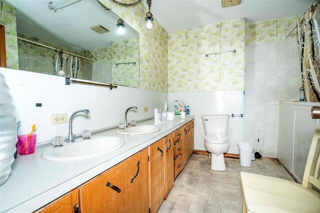 bathroom with wallpapered walls, a shower with curtain, toilet, double vanity, and tile walls