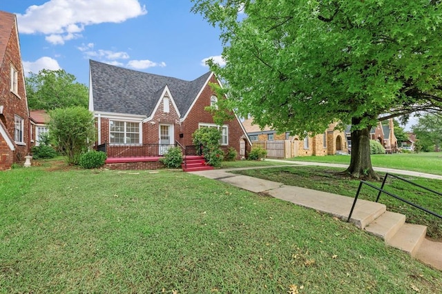 905 NE 21st St, Oklahoma City, OK 73105 - tudor house with brick siding, roof with shingles, and a deck