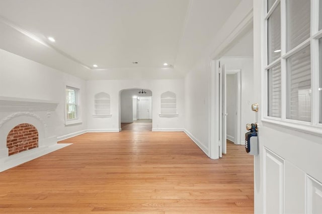 905 NE 21st St, Oklahoma City, OK 73105 - unfurnished living room featuring light wood-style flooring, arched walkways, recessed lighting, and baseboards