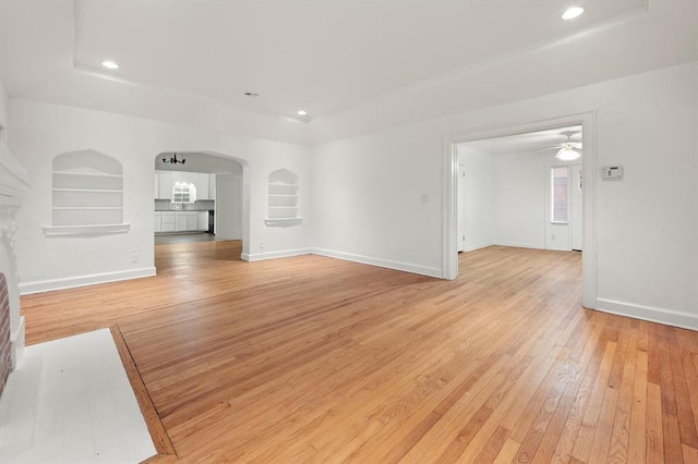 905 NE 21st St, Oklahoma City, OK 73105 - unfurnished living room featuring light wood-style flooring, a ceiling fan, arched walkways, recessed lighting, and baseboards