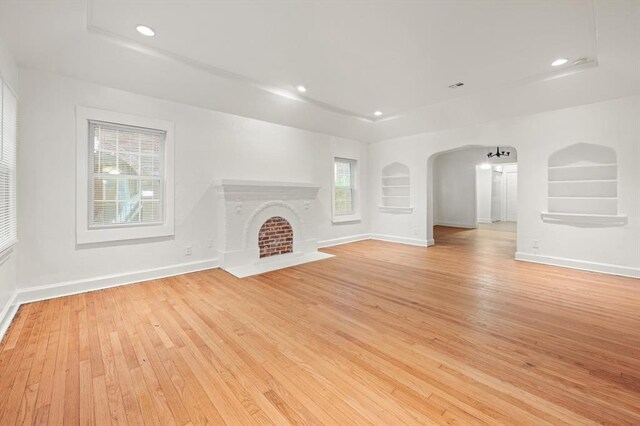 905 NE 21st St, Oklahoma City, OK 73105 - unfurnished living room featuring light wood-style flooring, baseboards, recessed lighting, built in shelves, and a fireplace with flush hearth