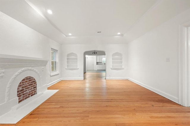 905 NE 21st St, Oklahoma City, OK 73105 - unfurnished living room with arched walkways, built in features, light wood-type flooring, baseboards, and recessed lighting