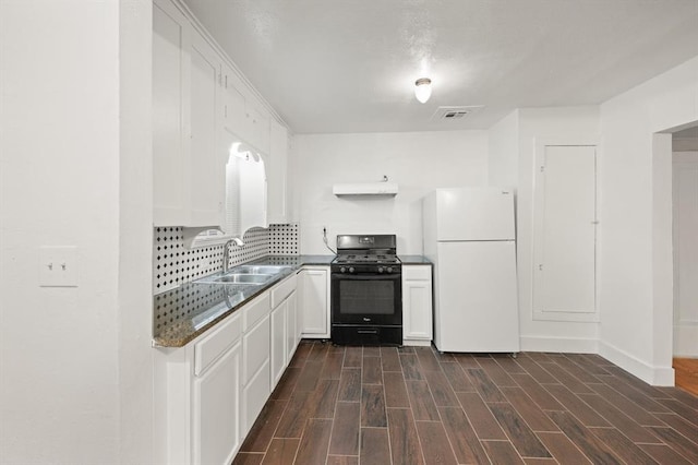 905 NE 21st St, Oklahoma City, OK 73105 - kitchen with black gas range, freestanding refrigerator, a sink, range hood, and white cabinetry