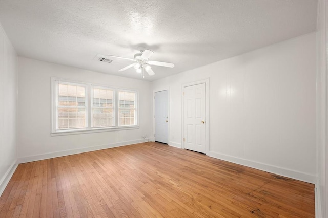 905 NE 21st St, Oklahoma City, OK 73105 - unfurnished bedroom with baseboards, light wood-type flooring, a ceiling fan, and a textured ceiling