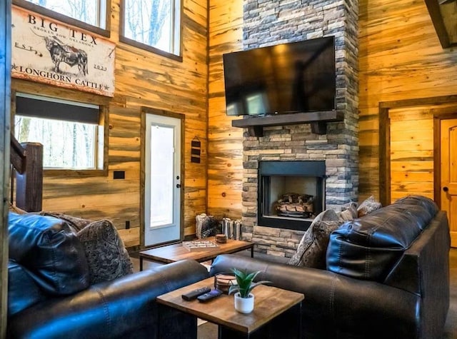 161 Champion Way, Broken Bow, OK 74728 - living room with wooden walls, a towering ceiling, plenty of natural light, and a stone fireplace