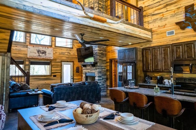 161 Champion Way, Broken Bow, OK 74728 - dining room featuring a towering ceiling, wood walls, and stairs