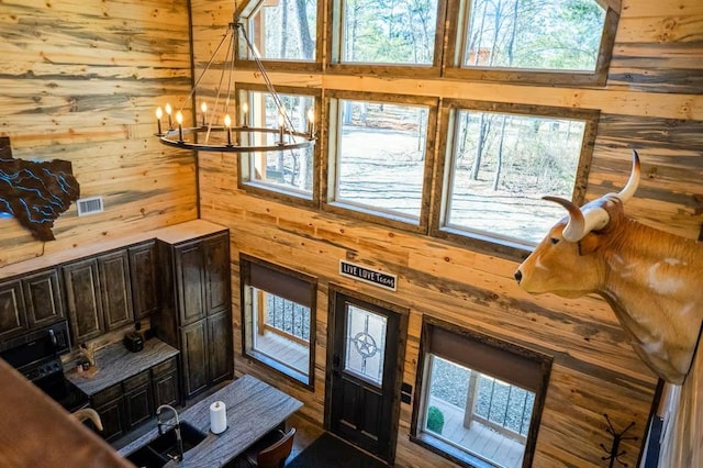 161 Champion Way, Broken Bow, OK 74728 - living room featuring wood walls, a chandelier, and plenty of natural light
