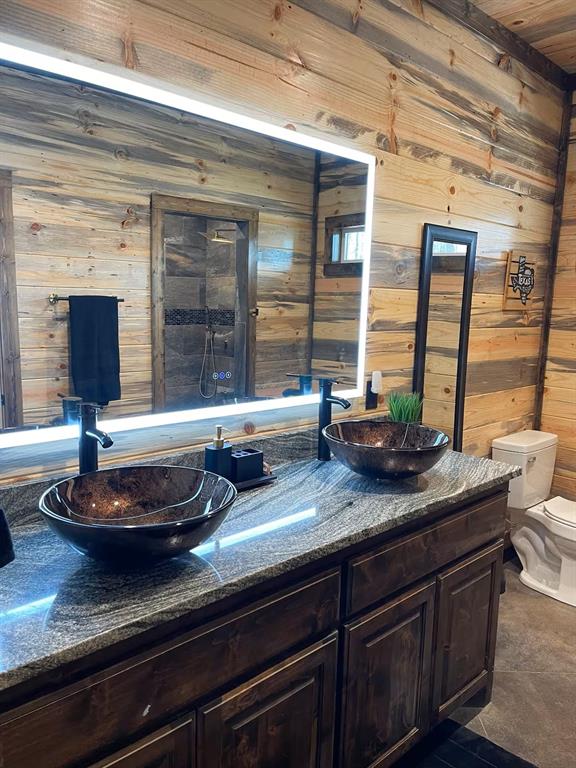 161 Champion Way, Broken Bow, OK 74728 - full bathroom with wood walls, double vanity, and toilet