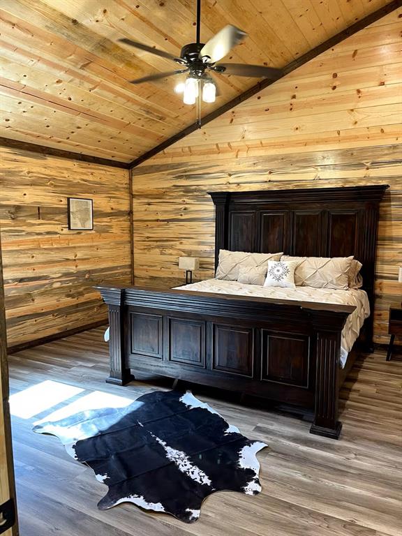 161 Champion Way, Broken Bow, OK 74728 - bedroom featuring wooden ceiling, lofted ceiling, wood walls, and wood finished floors