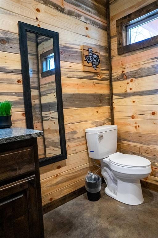 161 Champion Way, Broken Bow, OK 74728 - half bathroom featuring wooden walls, toilet, plenty of natural light, and vanity