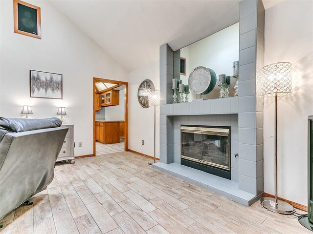 17612 Durbin Park Rd, Edmond, OK 73012 - living area featuring wood finished floors, vaulted ceiling, baseboards, and a tile fireplace