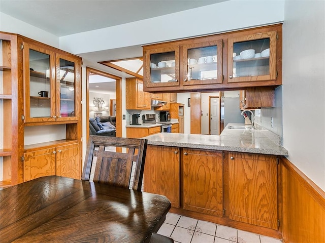 17612 Durbin Park Rd, Edmond, OK 73012 - kitchen with a sink, electric stove, brown cabinets, light tile patterned flooring, and glass insert cabinets